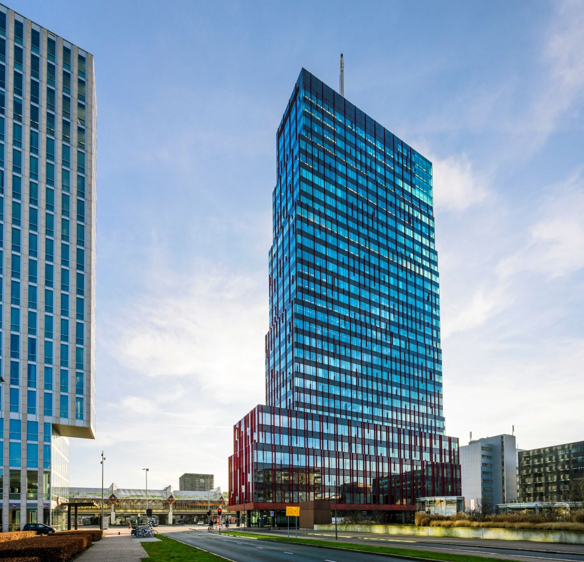 Modern high-rise building on P.J. Oudweg with a glass facade reflecting the sky.