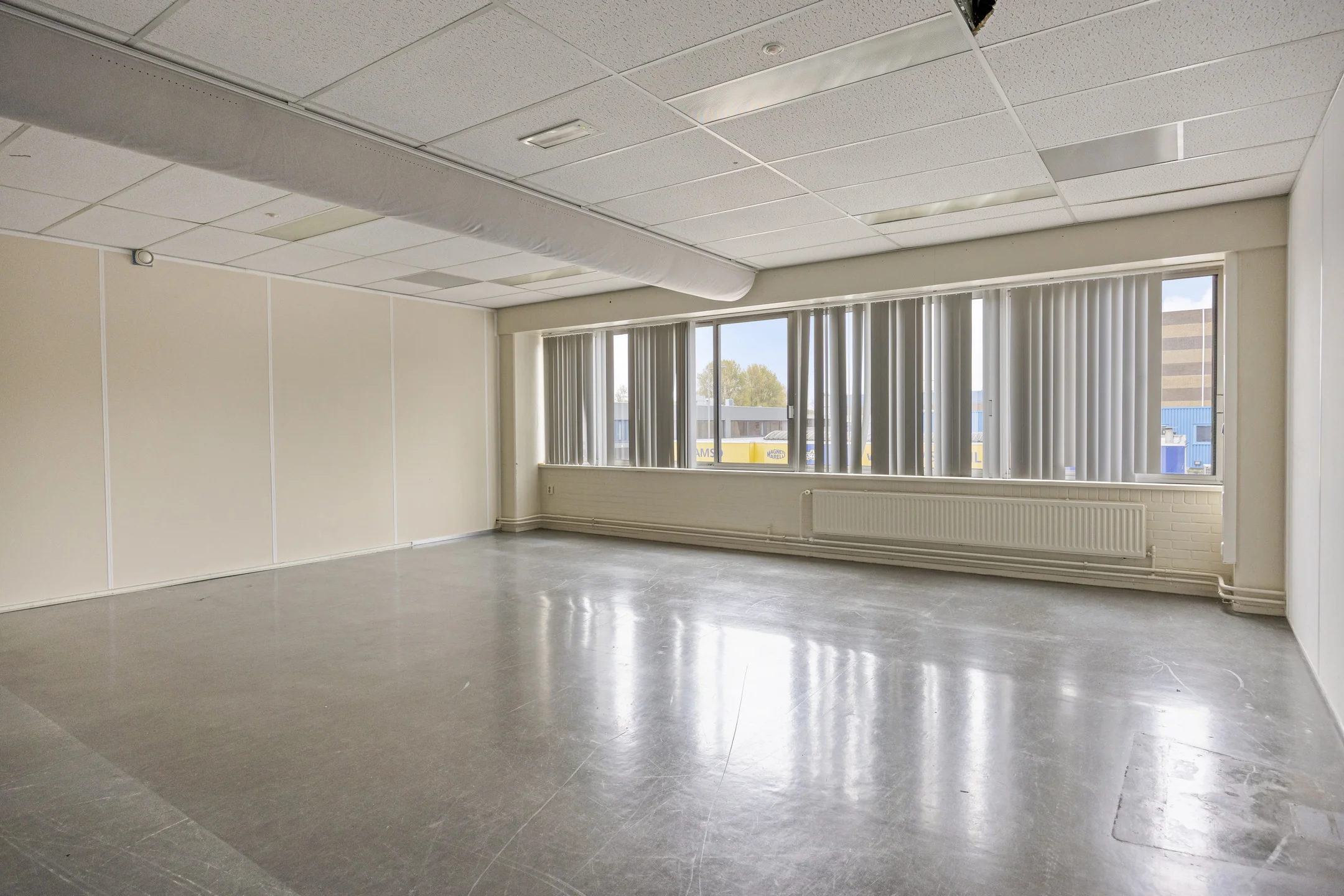 Empty office space with large windows and vertical blinds on Aluminiumstraat.