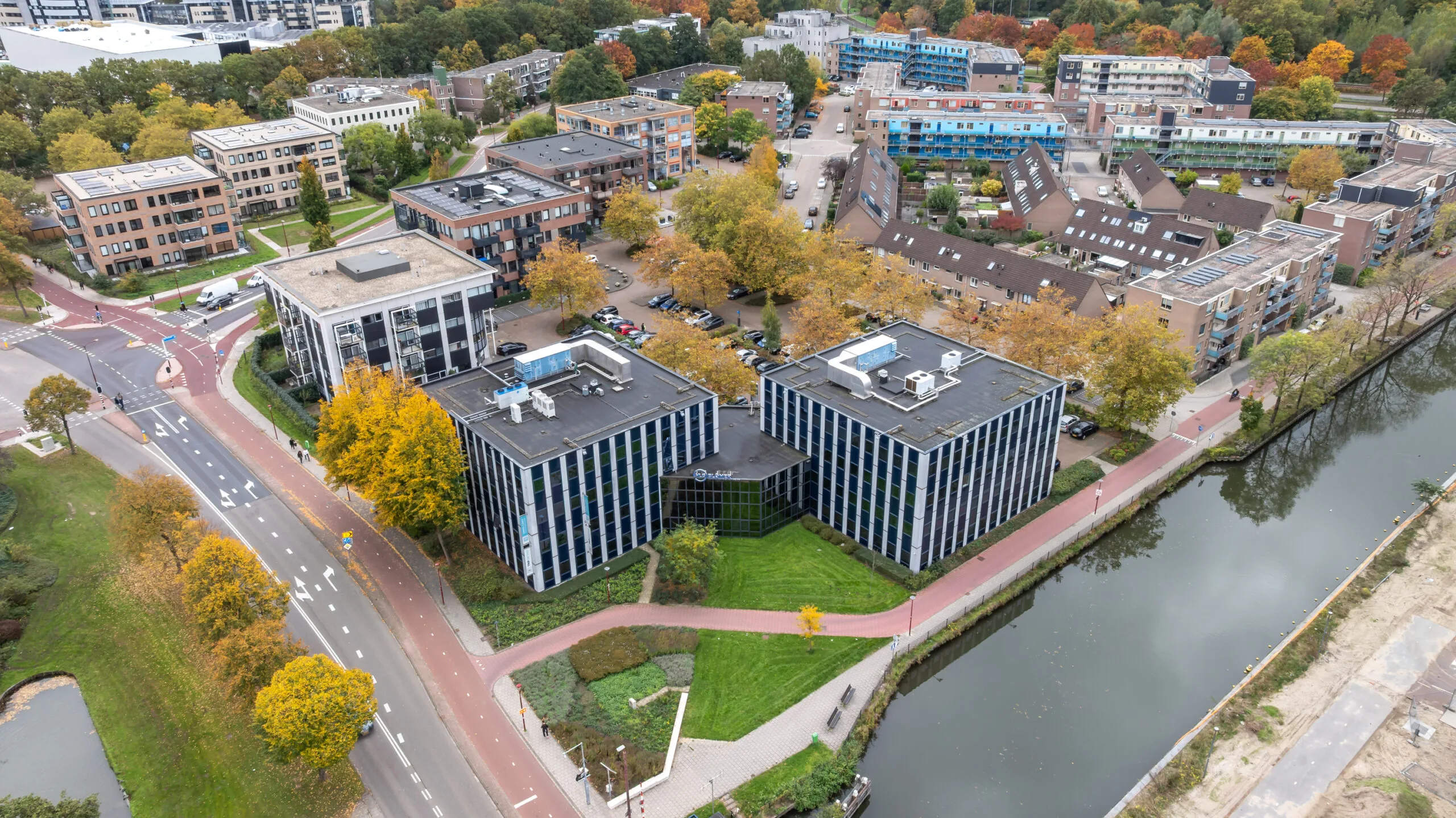 Aerial view of Krijtwal in a Dutch urban neighborhood with office buildings, residential apartments, and a canal.