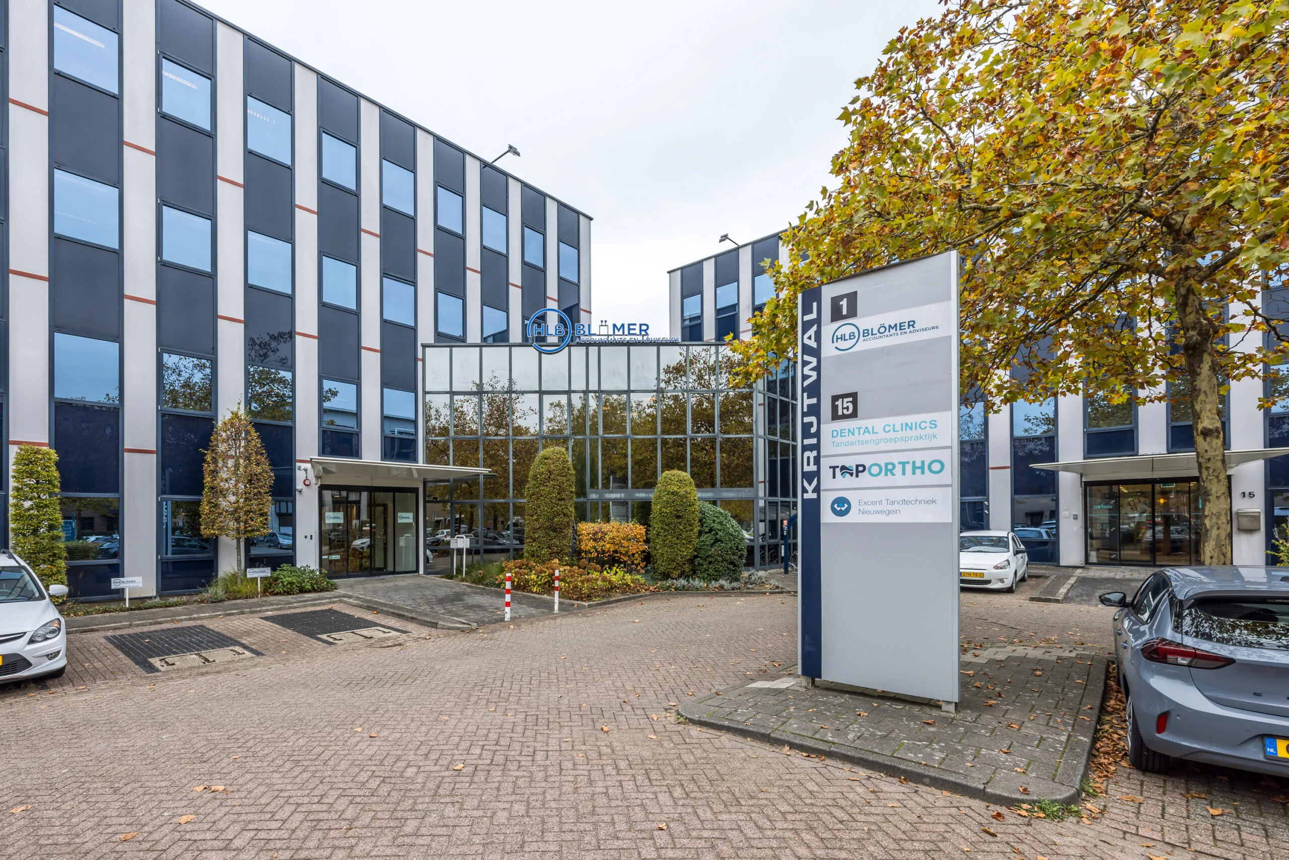 Modern office building on Krijtwal street with signs for HLB Blömer, Dental Clinics, Tportho, and Ecurat Tandtechniek.