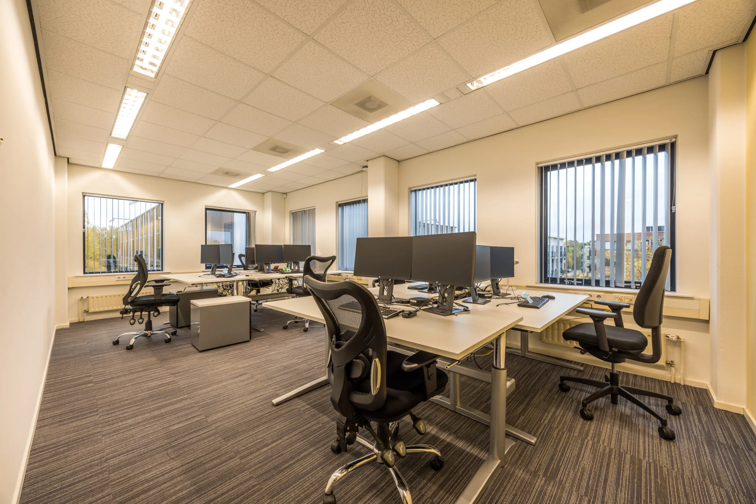 Modern office space with multiple desks, ergonomic chairs, and computer monitors at Krijtwal 251564196.
