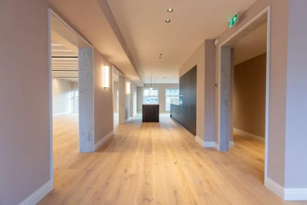 Modern office interior at Rokin with wooden flooring, recessed lighting, and an open layout.