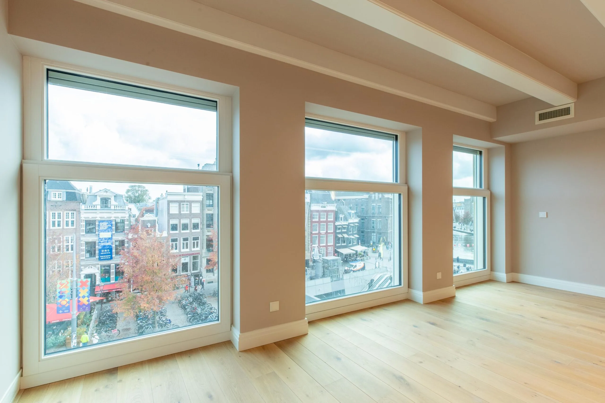 Bright empty room with large windows overlooking Rokin street in Amsterdam.