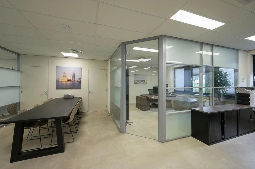 Modern office interior with a glass-walled meeting room, a long conference table, and neutral-toned furnishings at Ebweg 252313332.