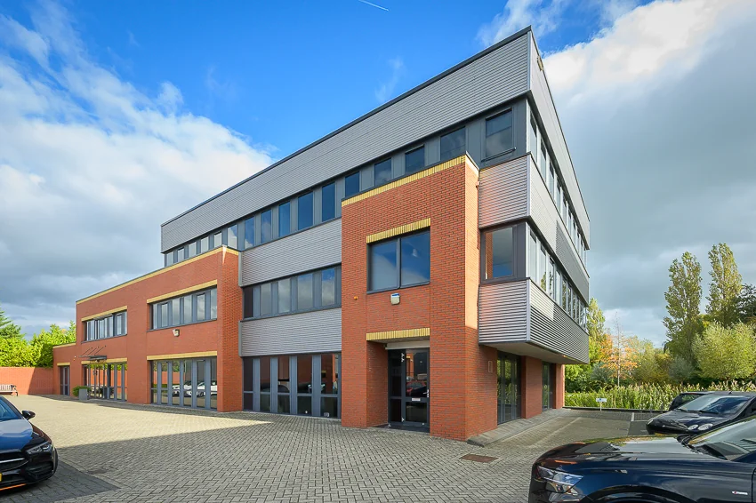 Modern three-story office building on Ebweg with a red brick and grey metal facade.