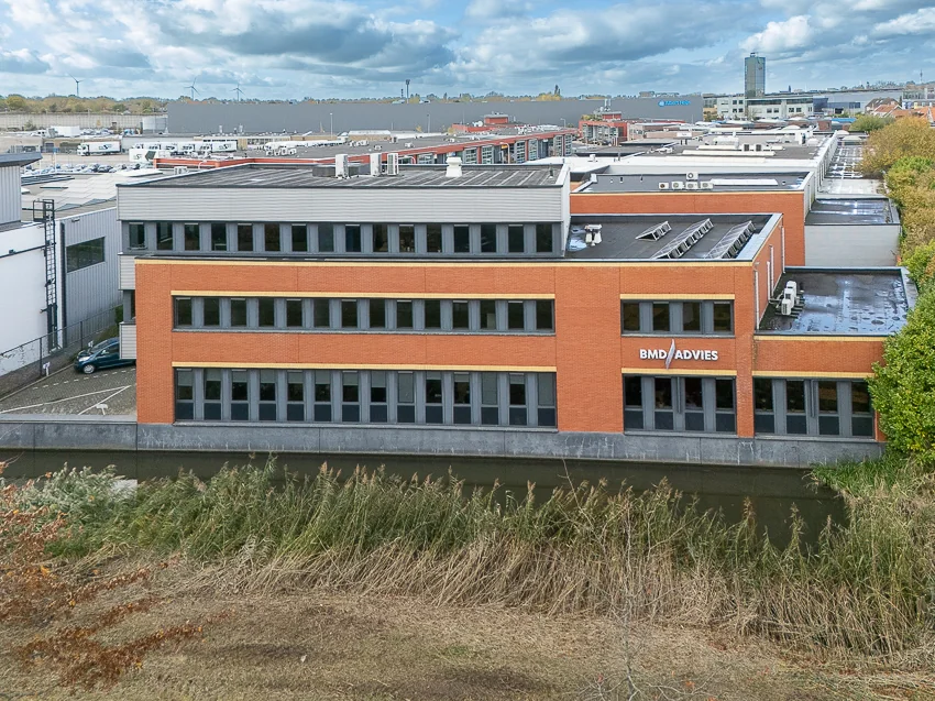 Modern office building of BMD Advies located along a canal in an industrial area.