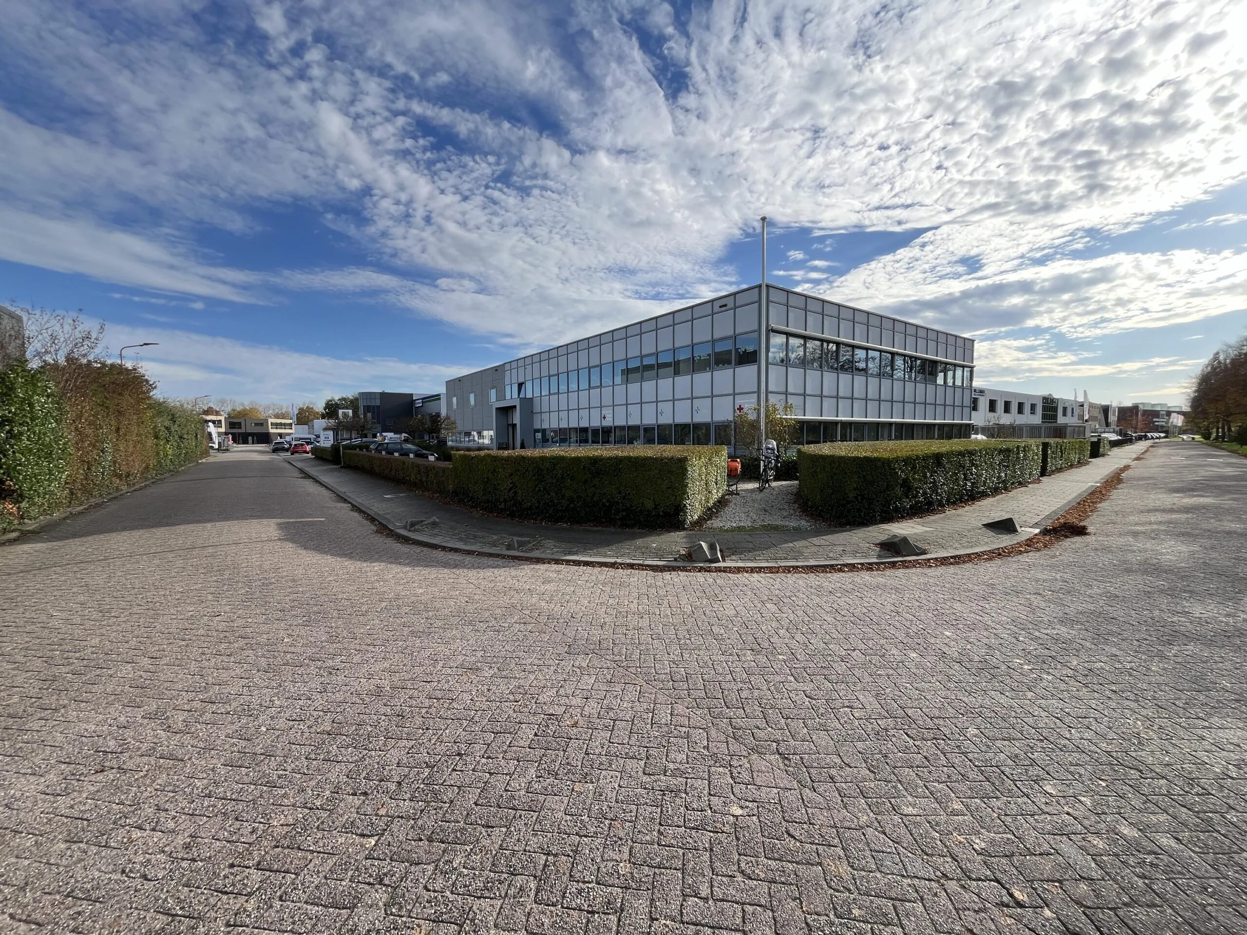 Modern industrial building on Archimedesbaan street with clear skies and surrounding greenery.