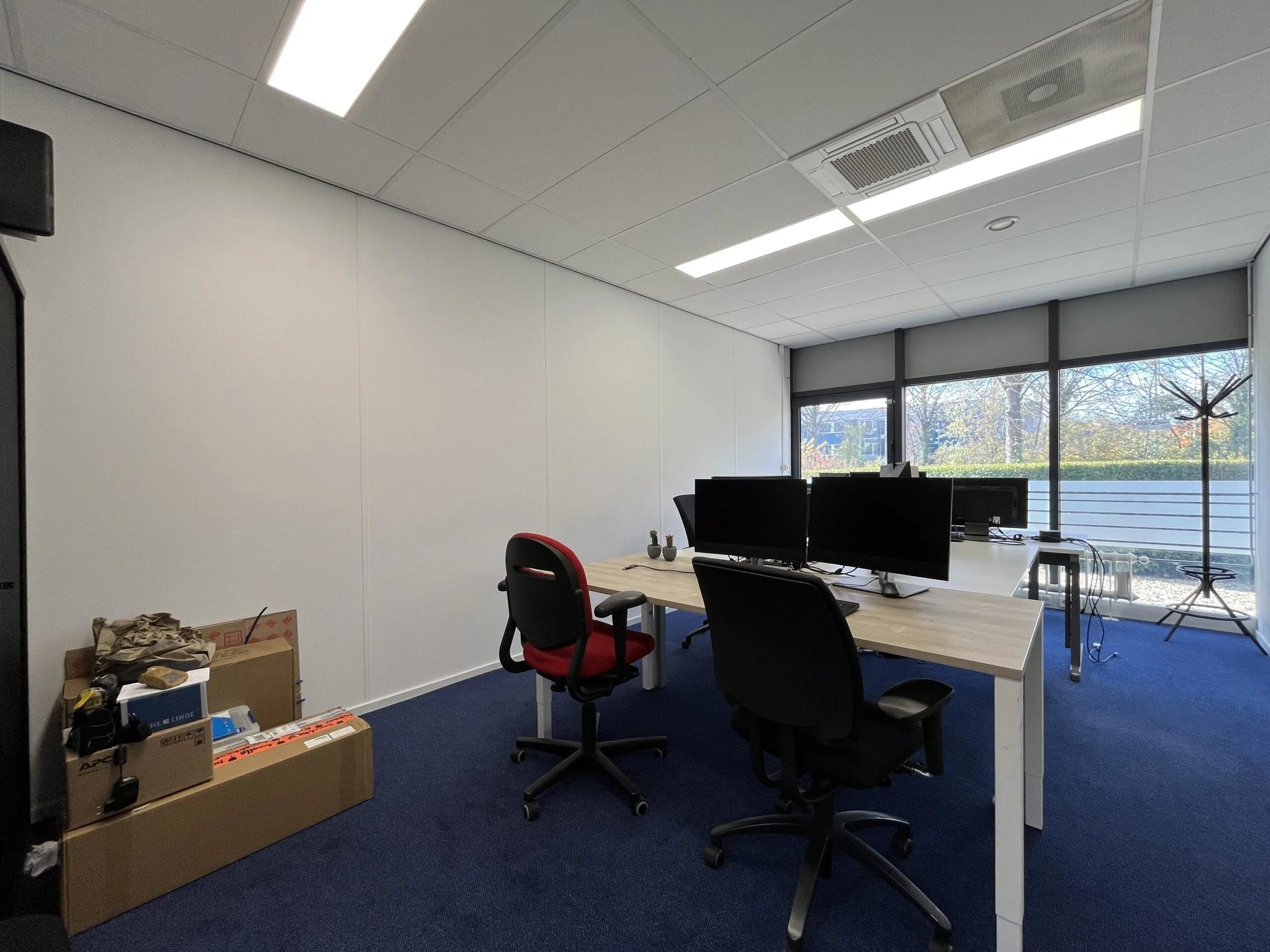 Modern office space on Archimedesbaan with desks, computer monitors, and large windows providing natural light.