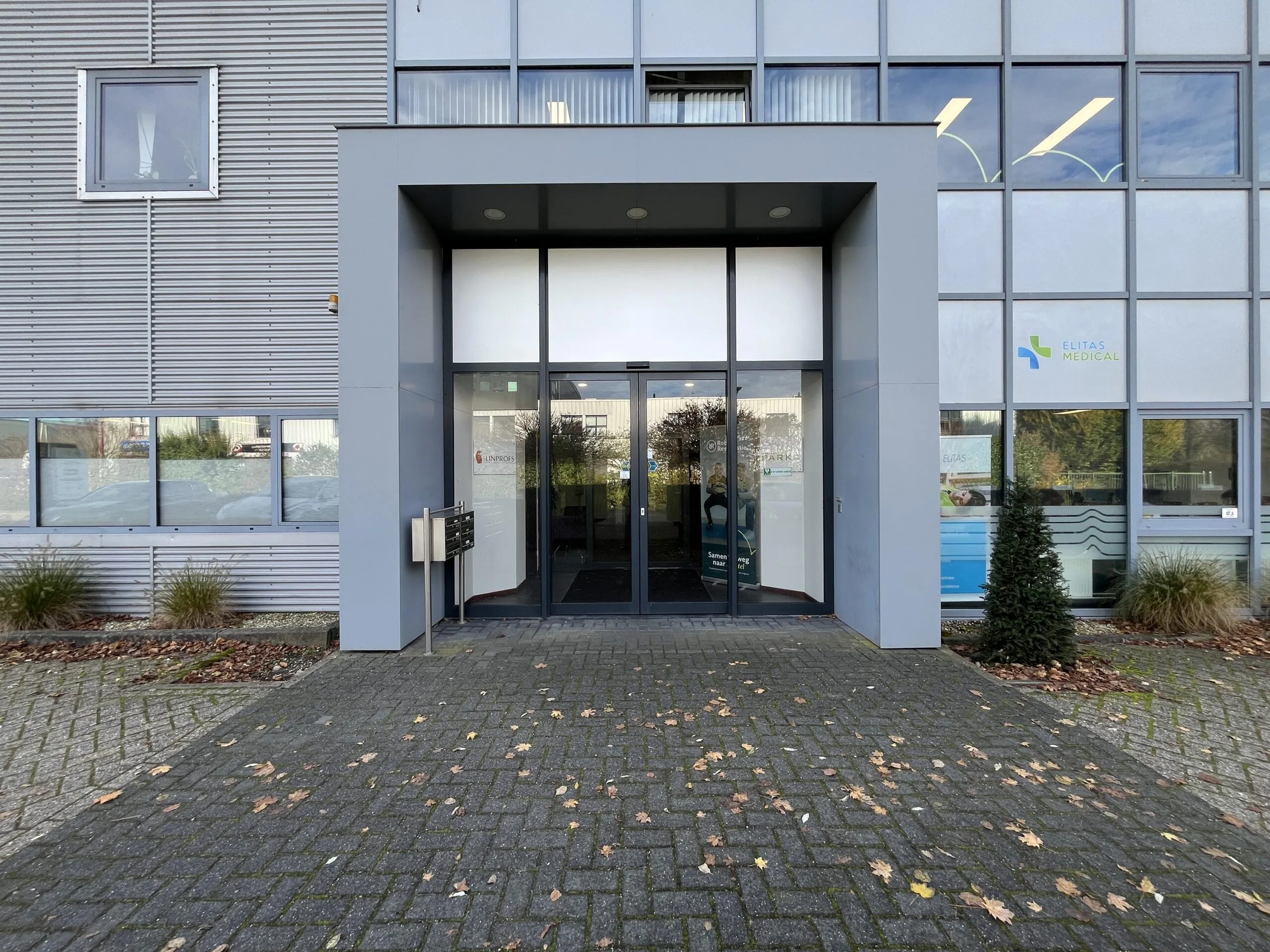 Entrance of a modern office building at Archimedesbaan, featuring signs for Elitas Medical and Inpos.