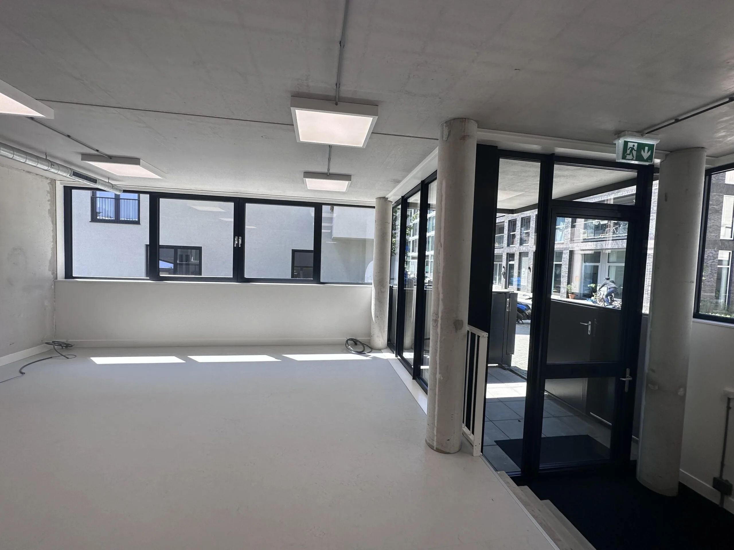 Bright and empty commercial space on Willem Parelstraat with large windows and glass entrance door.