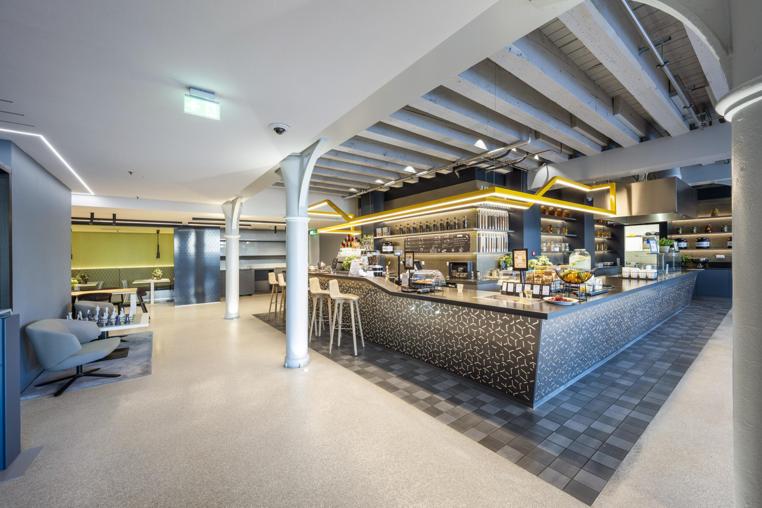 Modern cafeteria area at Nieuwevaart with a central counter, high stools, and contemporary lighting.