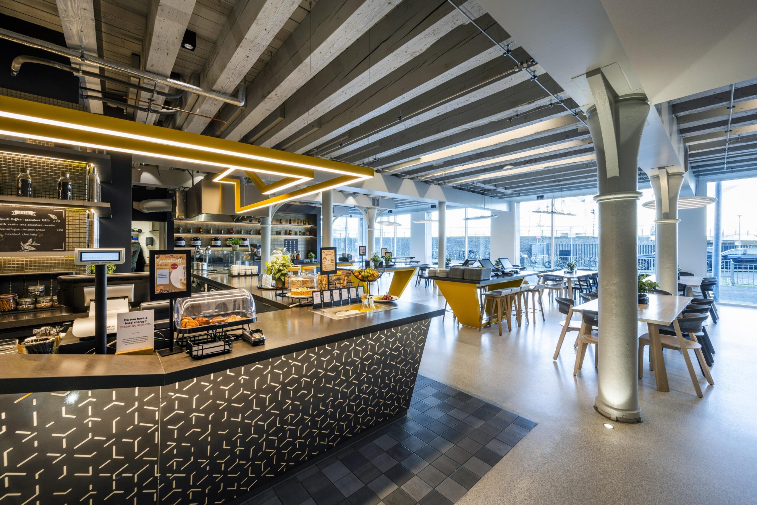 Modern café interior at Nieuwe Vaart featuring a stylish counter, seating area, and industrial design elements.