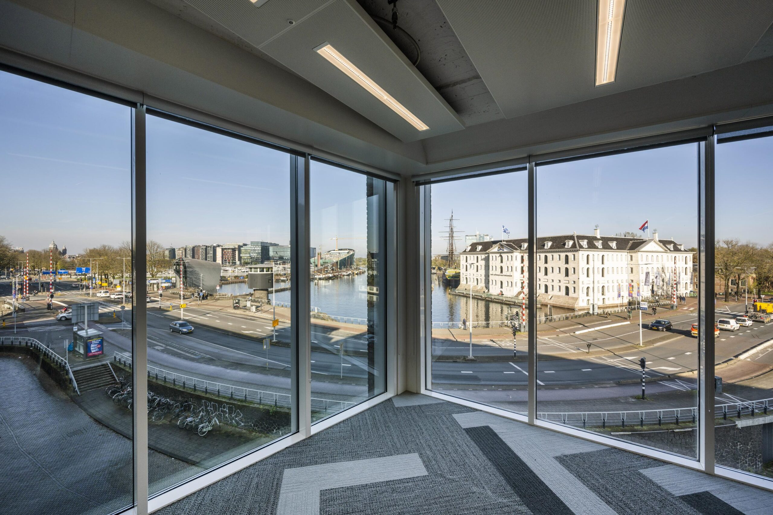Corner window view of Nieuwe Vaart in Amsterdam, showcasing the Maritime Museum and surrounding roads and waterways.