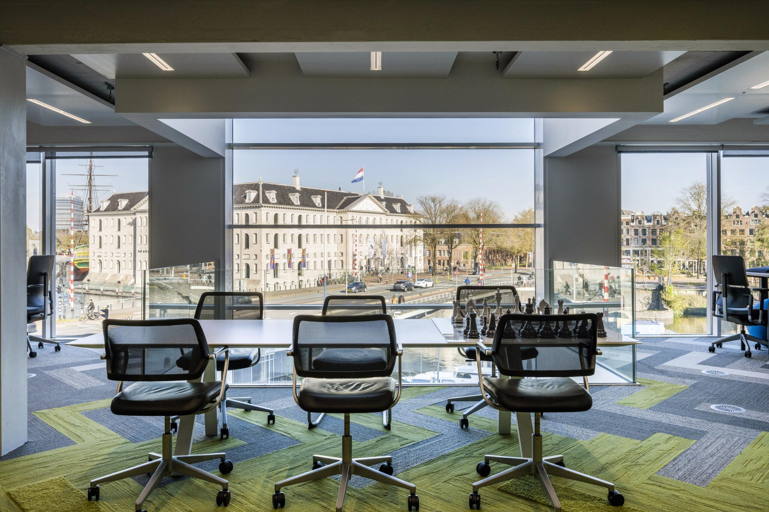 Modern office space with a view of the Dutch National Maritime Museum and the Nieuwe Vaart canal in Amsterdam.