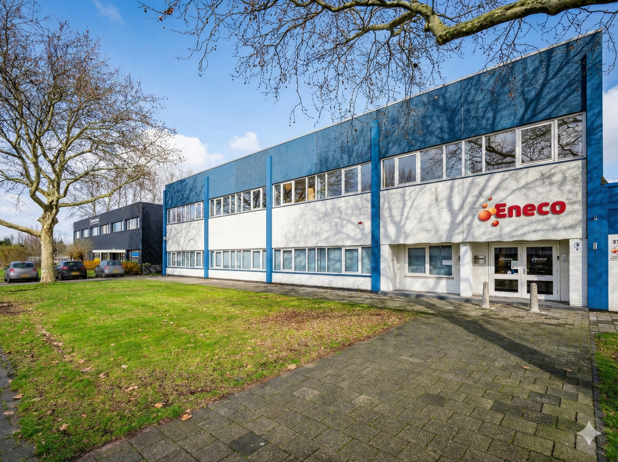 Vooraanzicht van een kantoorgebouw van Eneco aan de Gravelandseweg, omgeven door een grasveld en bomen.
