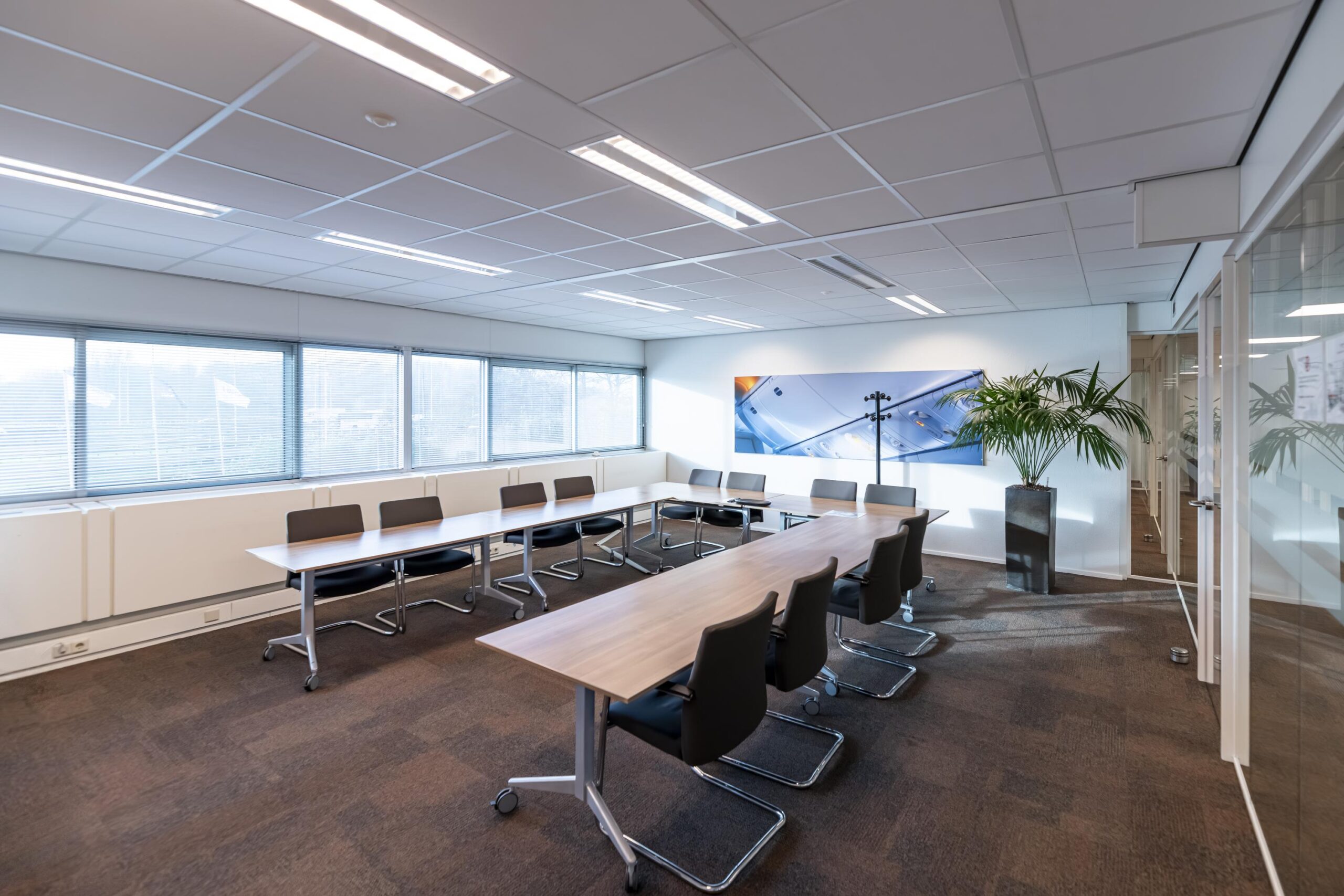 Vergaderruimte aan de Seattleweg met moderne inrichting, grote ramen en een lange tafel met stoelen.