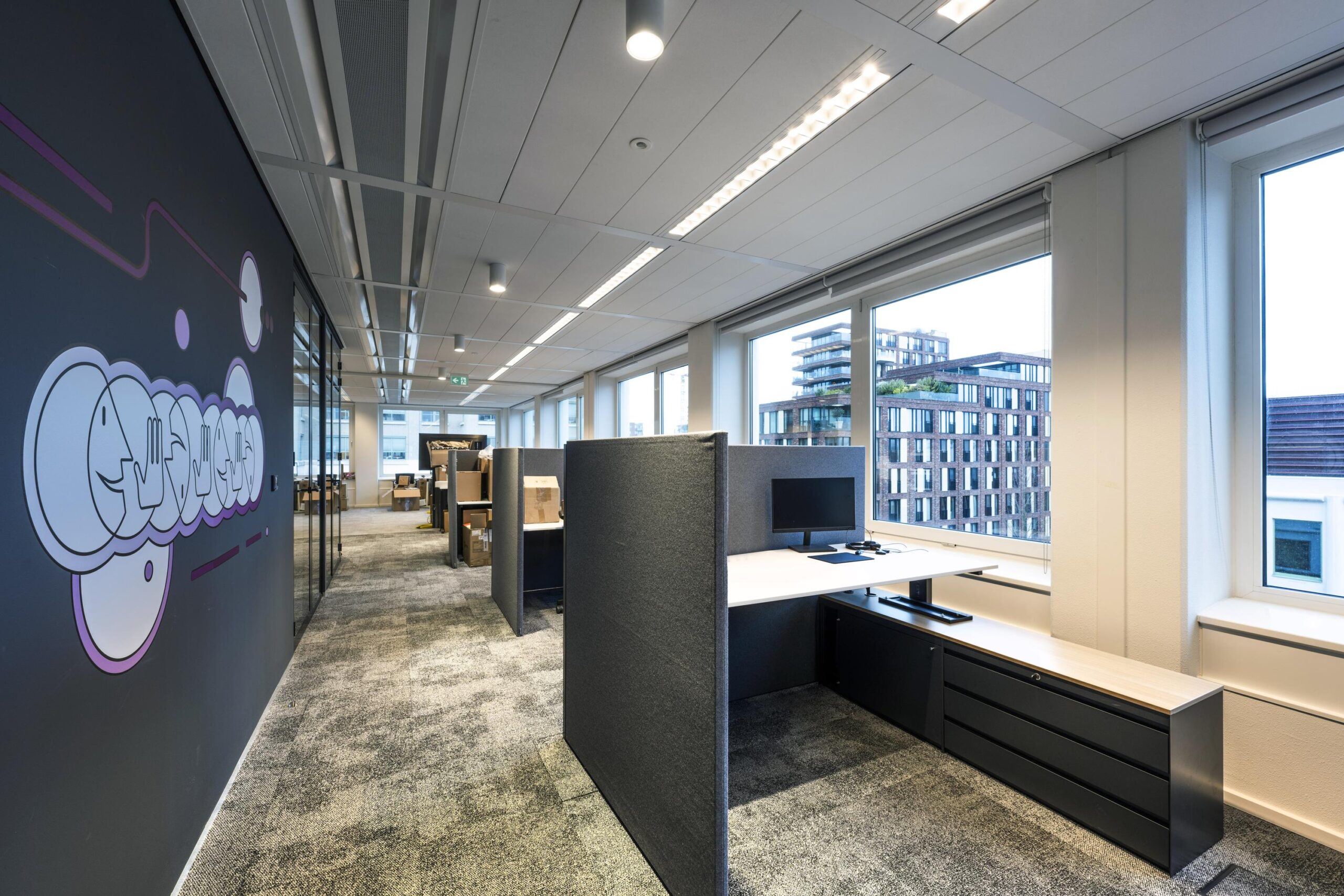 Moderne kantoortuin met werkplekken, uitzicht op een stad en een muurdecoratie met het woord "Stroombaan".