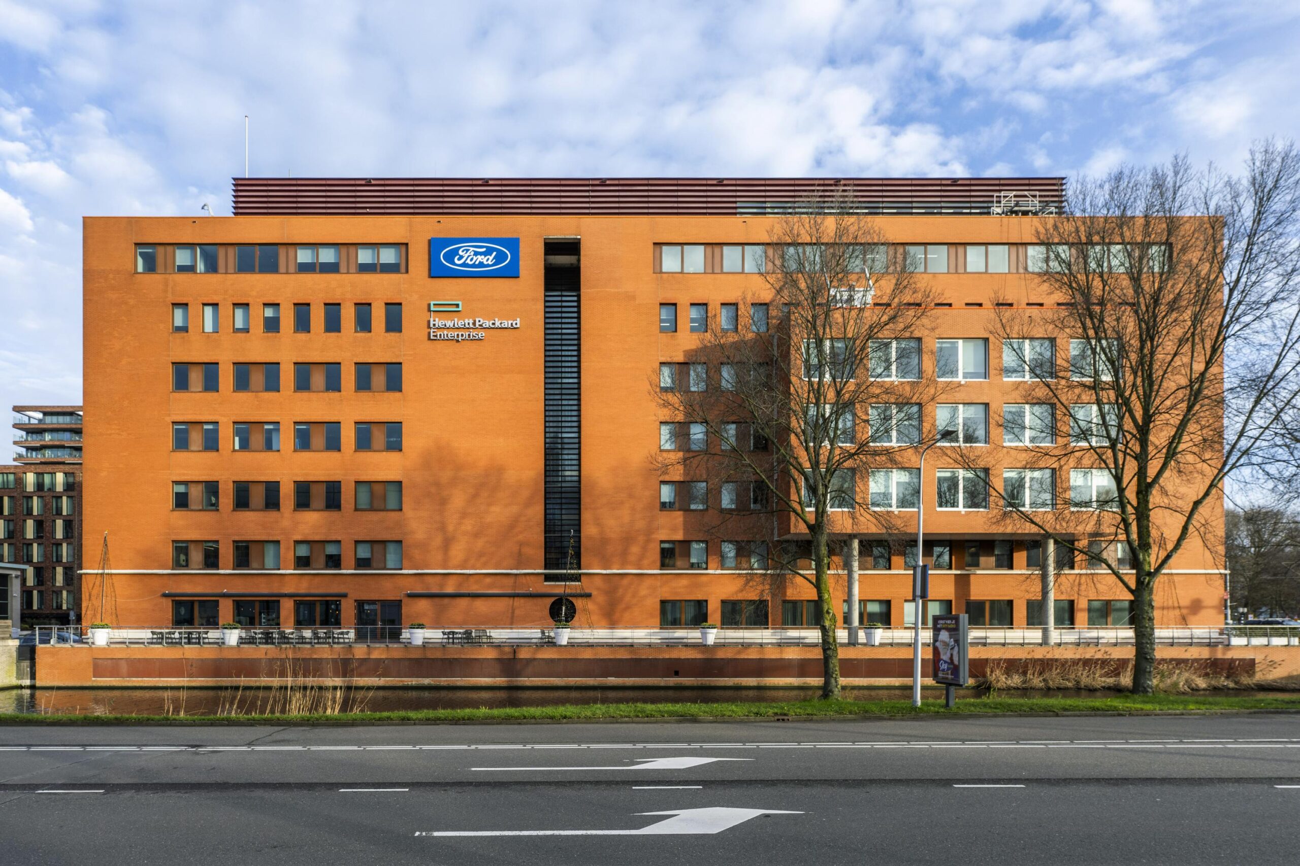 Kantoorgebouw aan de Stroombaan in Amstelveen met logo's van Ford en Hewlett Packard Enterprise op de gevel.