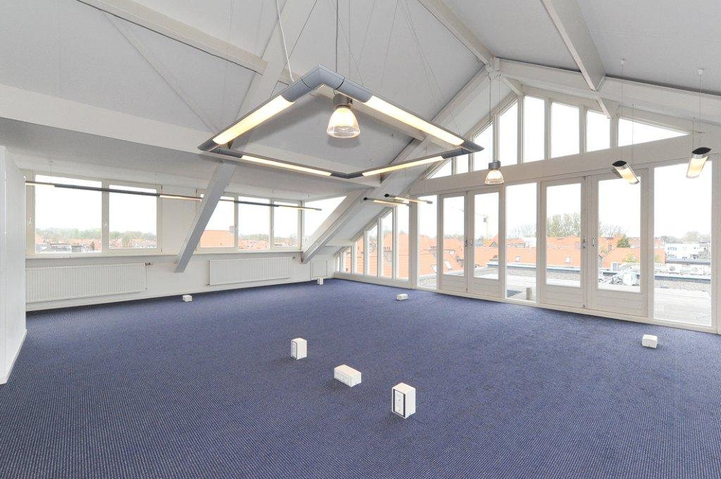 Licht en ruim kantoorpand aan het Oosteinde met grote ramen en modern verlichtingsarmatuur.
