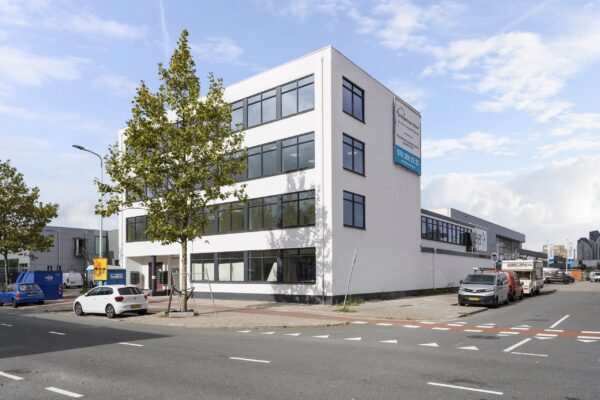 Wit kantoorgebouw aan de Mercuriusweg met meerdere geparkeerde auto’s en een duidelijke bedrijfsreclame aan de gevel.
