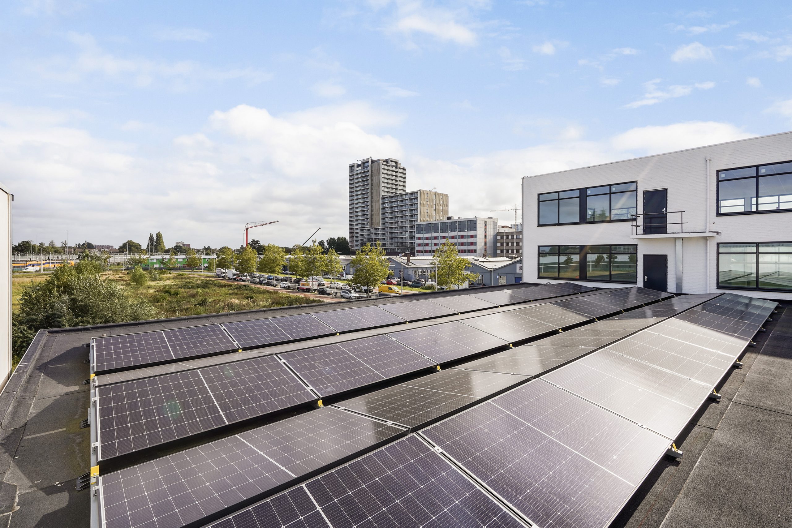Zonnepanelen op het dak van een bedrijfsgebouw aan de Mercuriusweg met uitzicht op een stedelijke omgeving.