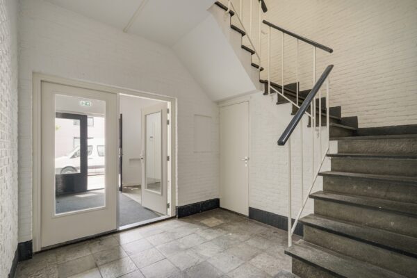 Entreehal met trap en deur naar buiten aan de Mercuriusweg.