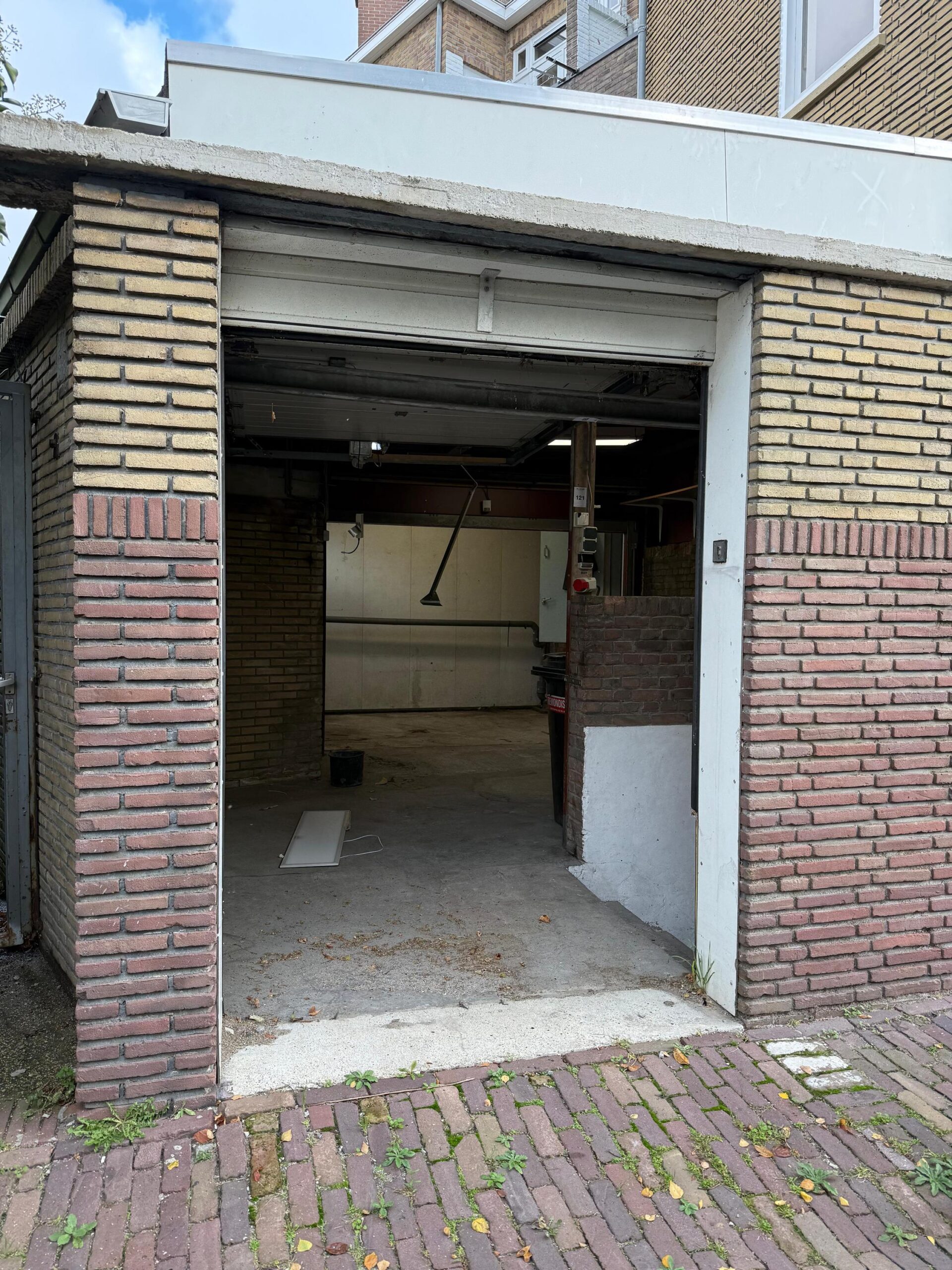 Openstaande garagedeur aan de Prinses Mariannelaan met zicht op een lege, deels betegelde garage.