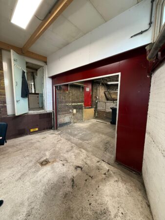 Verlaten en deels gerenoveerde ruimte aan de Prinses Mariannelaan met zicht op een doorgang naar een andere kamer.