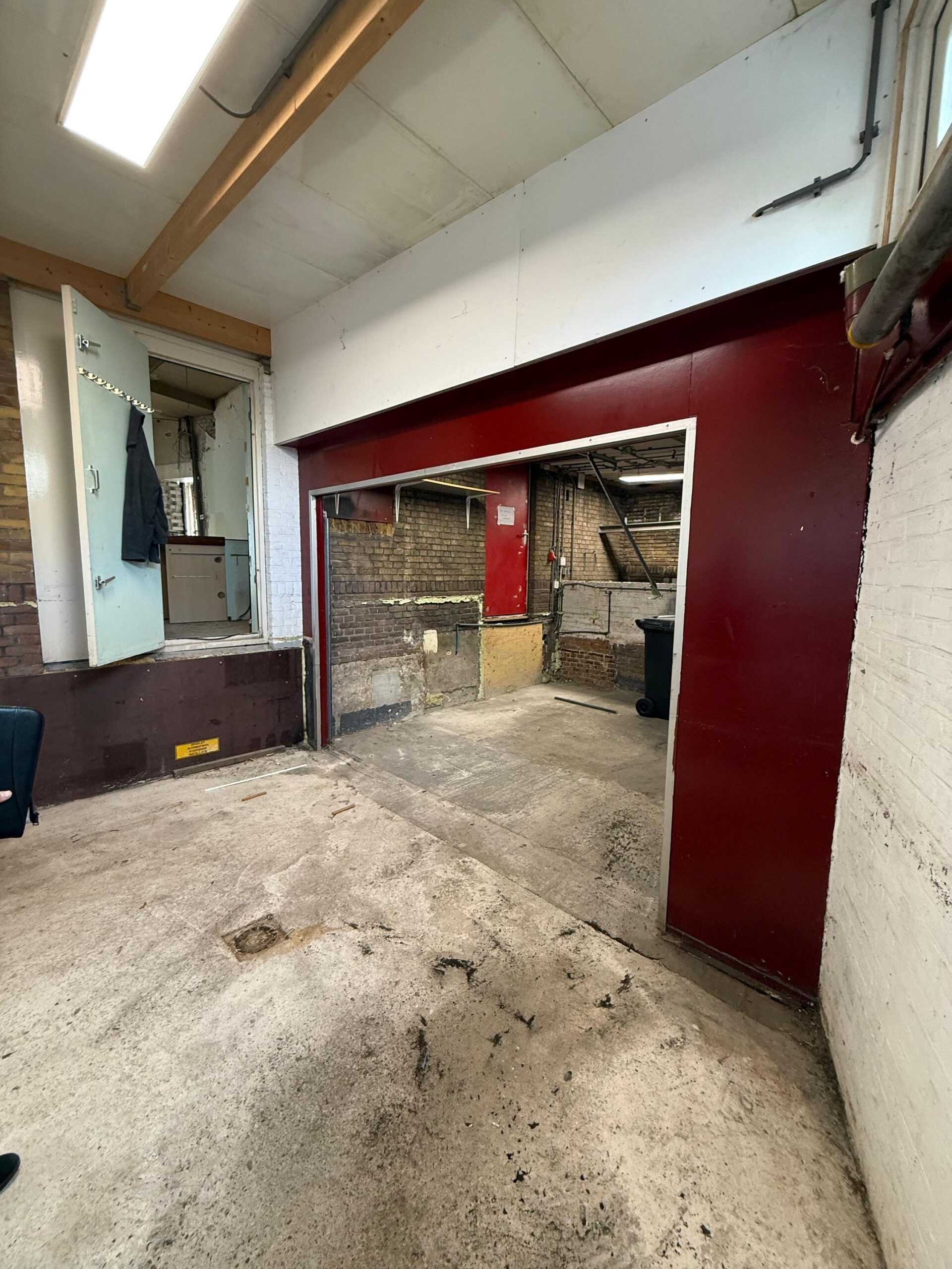 Verlaten en deels gerenoveerde ruimte aan de Prinses Mariannelaan met zicht op een doorgang naar een andere kamer.