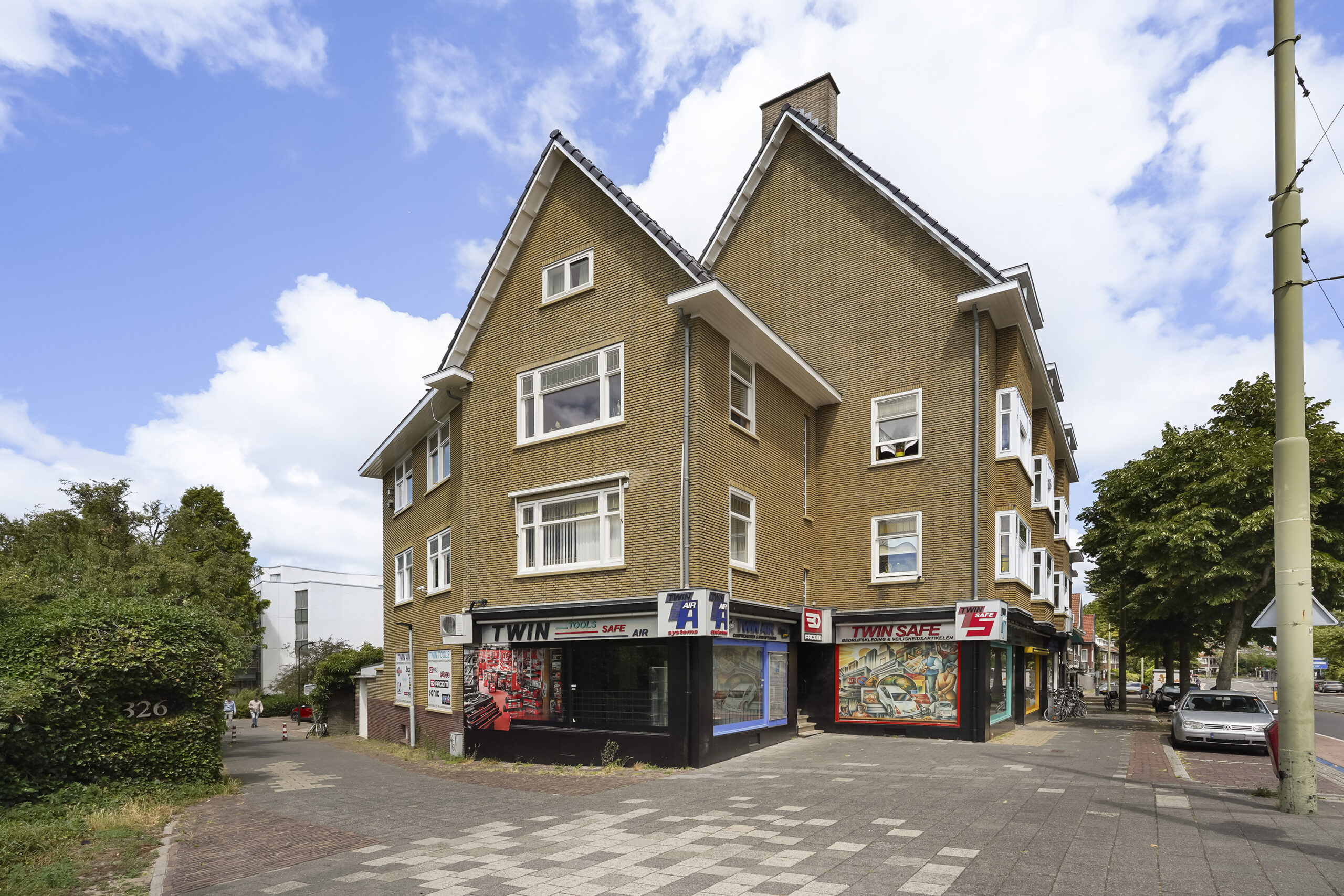 Hoekpand aan de Prinses Mariannelaan met winkels op de begane grond en woningen erboven.