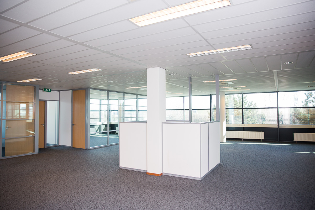 Moderne, lege kantoorruimte aan de Laan van s-Gravenmade met glazen wanden en systeemplafond.