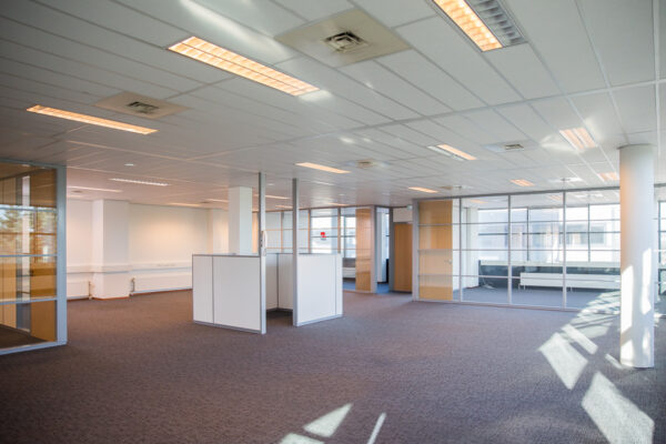 Lichte en ruime open kantoorruimte aan de Laan van s-Gravenmade met glazen scheidingswanden en systeemplafond.