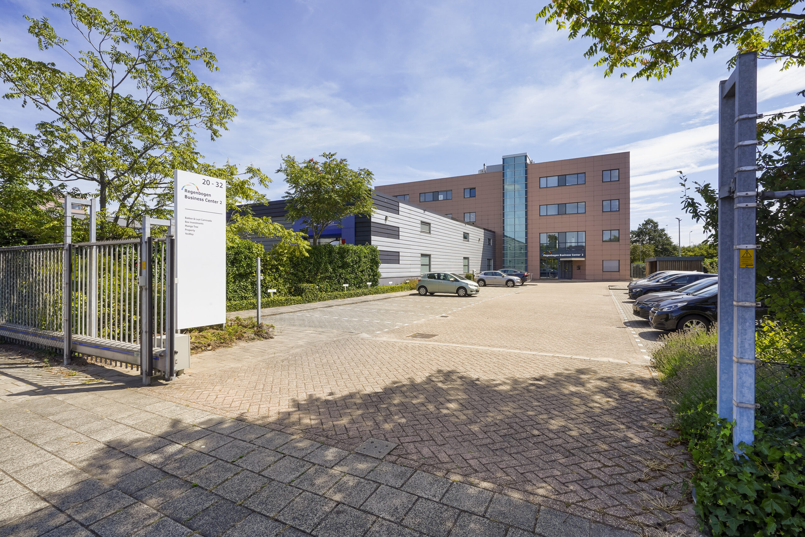 Vooraanzicht van het Regenboog Business Center 2 aan de Laan van ’s-Gravenmade met parkeerterrein en toegangspoort.