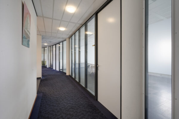 Moderne kantoorhal met glazen kantoordeuren aan de Laan van ’s-Gravenmade.
