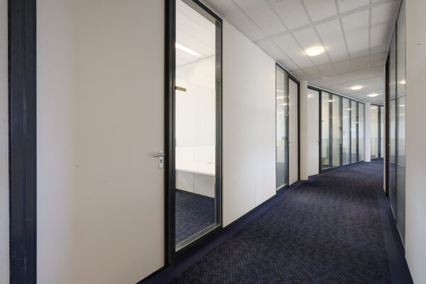 Gang met kantoorruimtes en glazen deuren aan de Laan van S-Gravenmade.