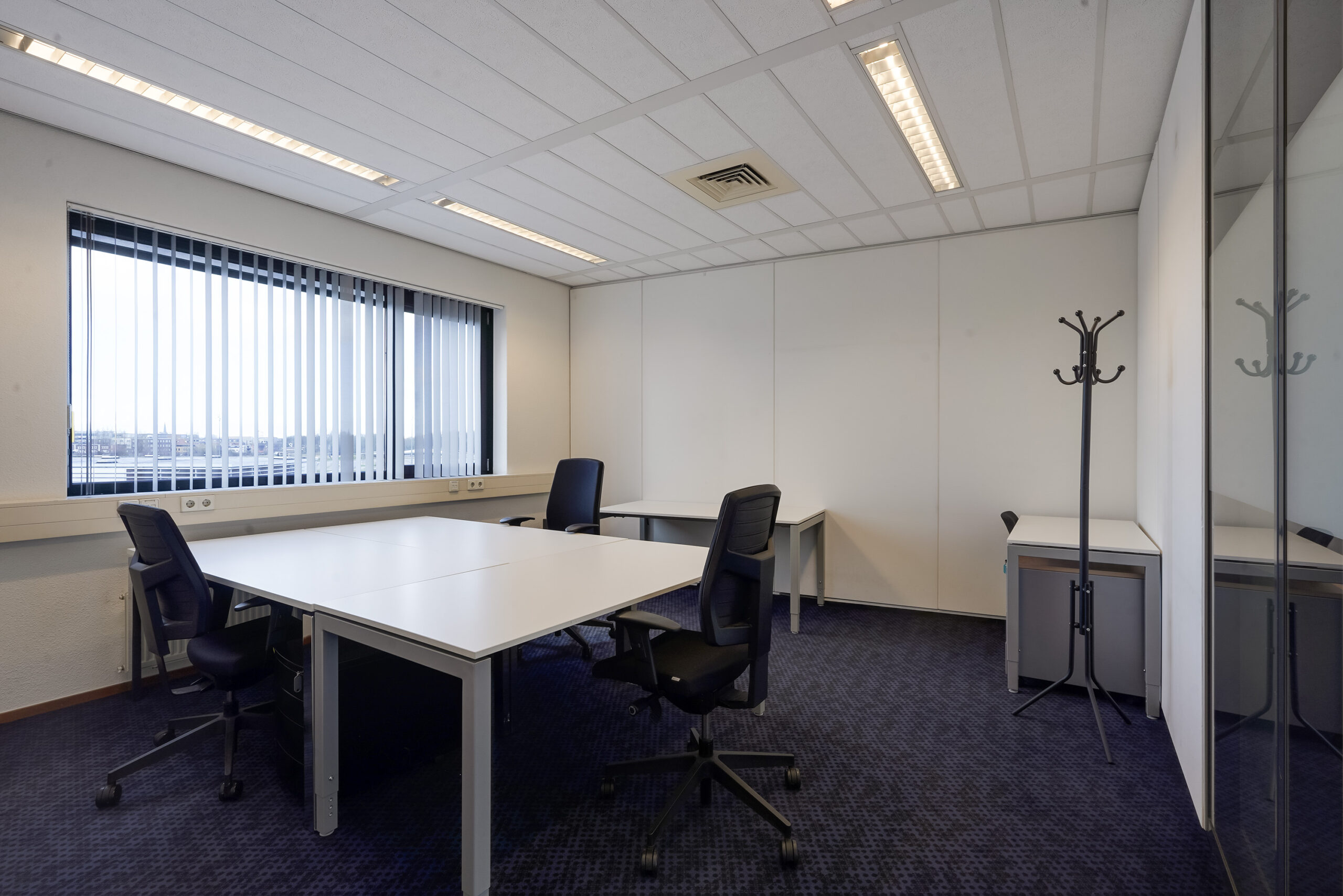 Modern, licht kantoor met vier bureaus en bureaustoelen aan de Laan van S-Gravenmade.
