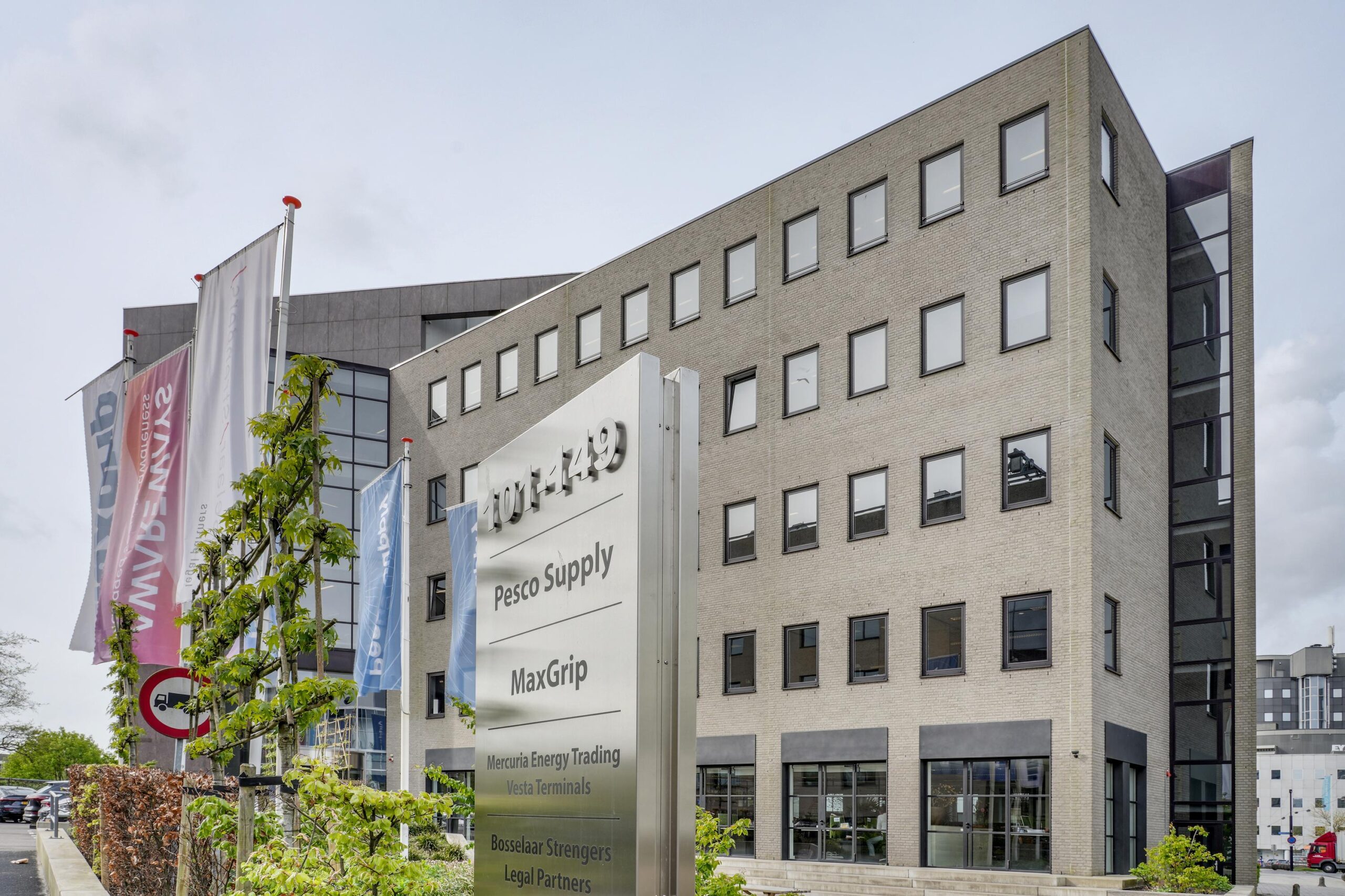 Kantoorgebouw aan de Euclideslaan met bedrijfsnamen op een groot gevelbord en vlaggenmast op de voorgrond.