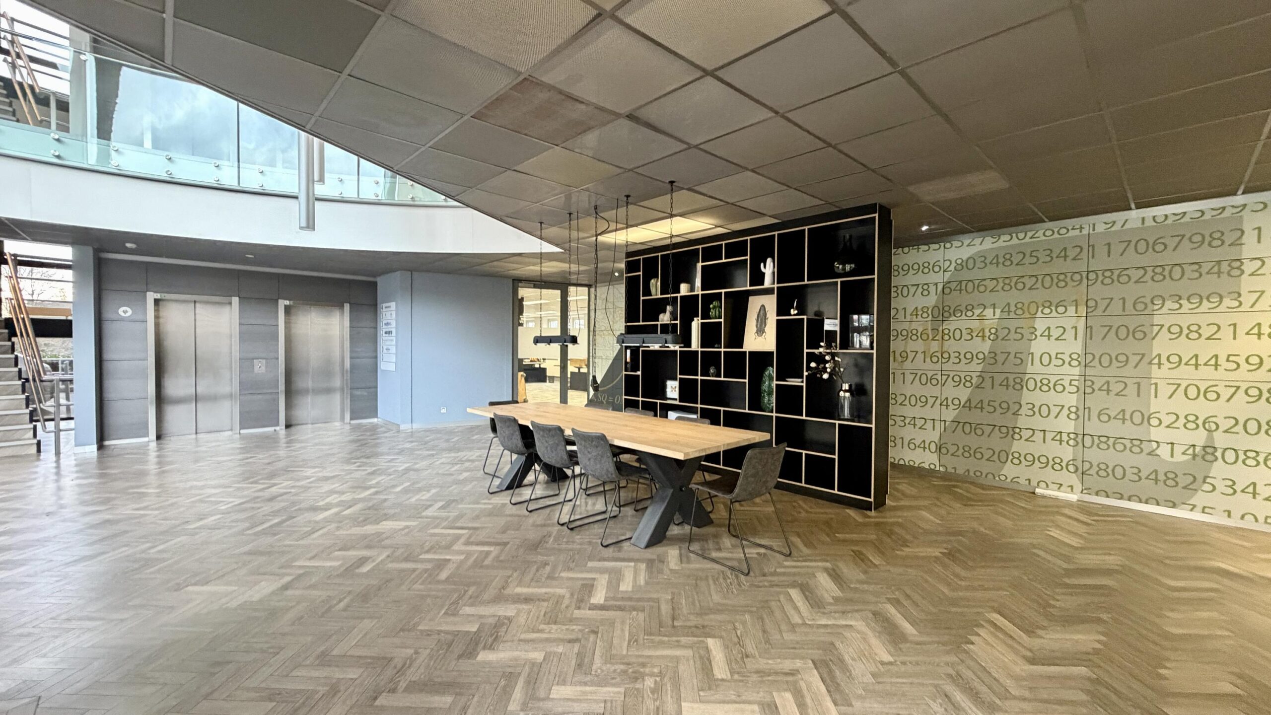 Moderne kantoorruimte aan de Euclideslaan met een vergadertafel, open wandkast en opvallende muurdecoratie met cijfers.