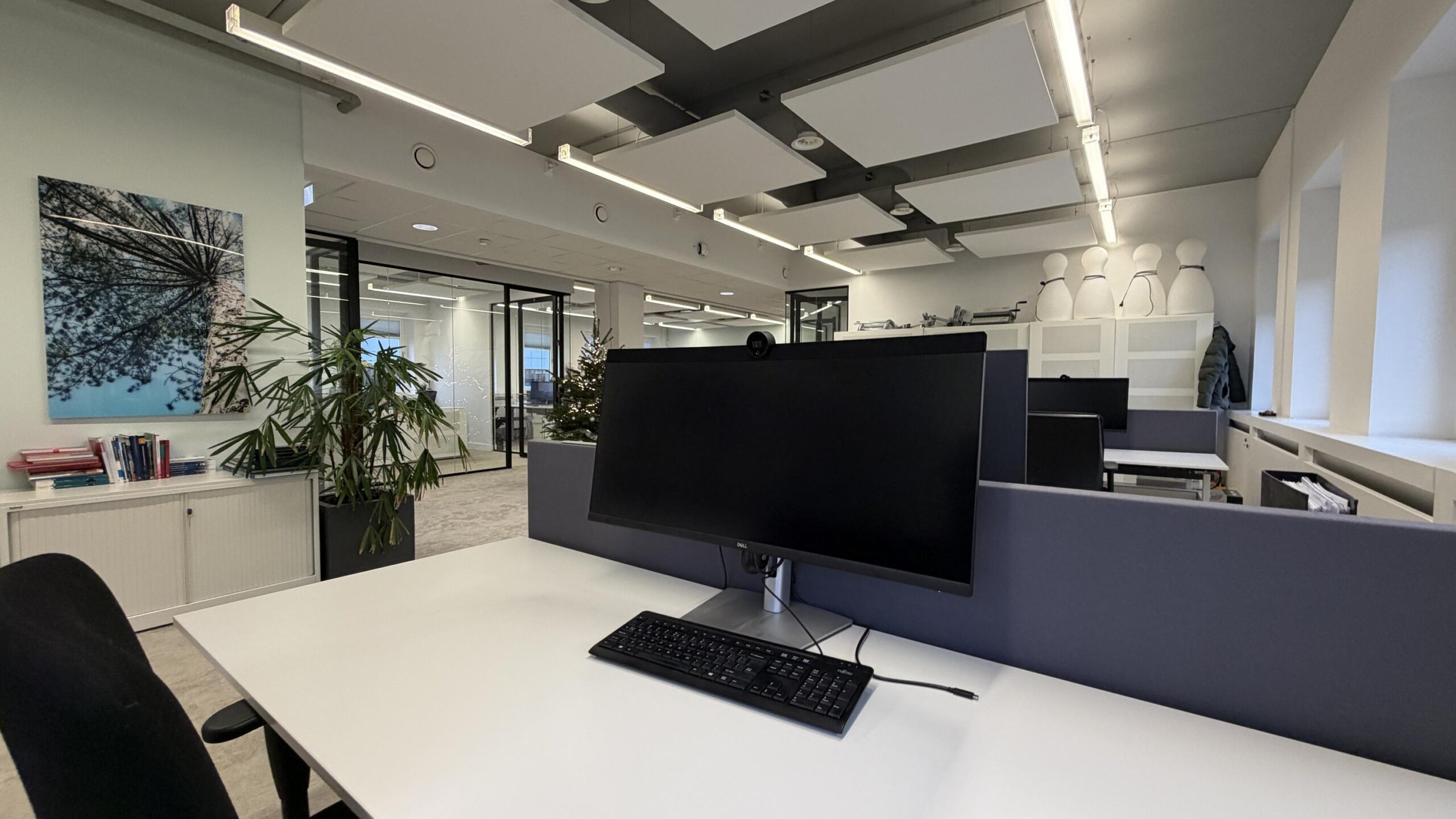 Moderne open kantoorruimte aan de Euclideslaan met werkplekken, planten en glazen wanden.