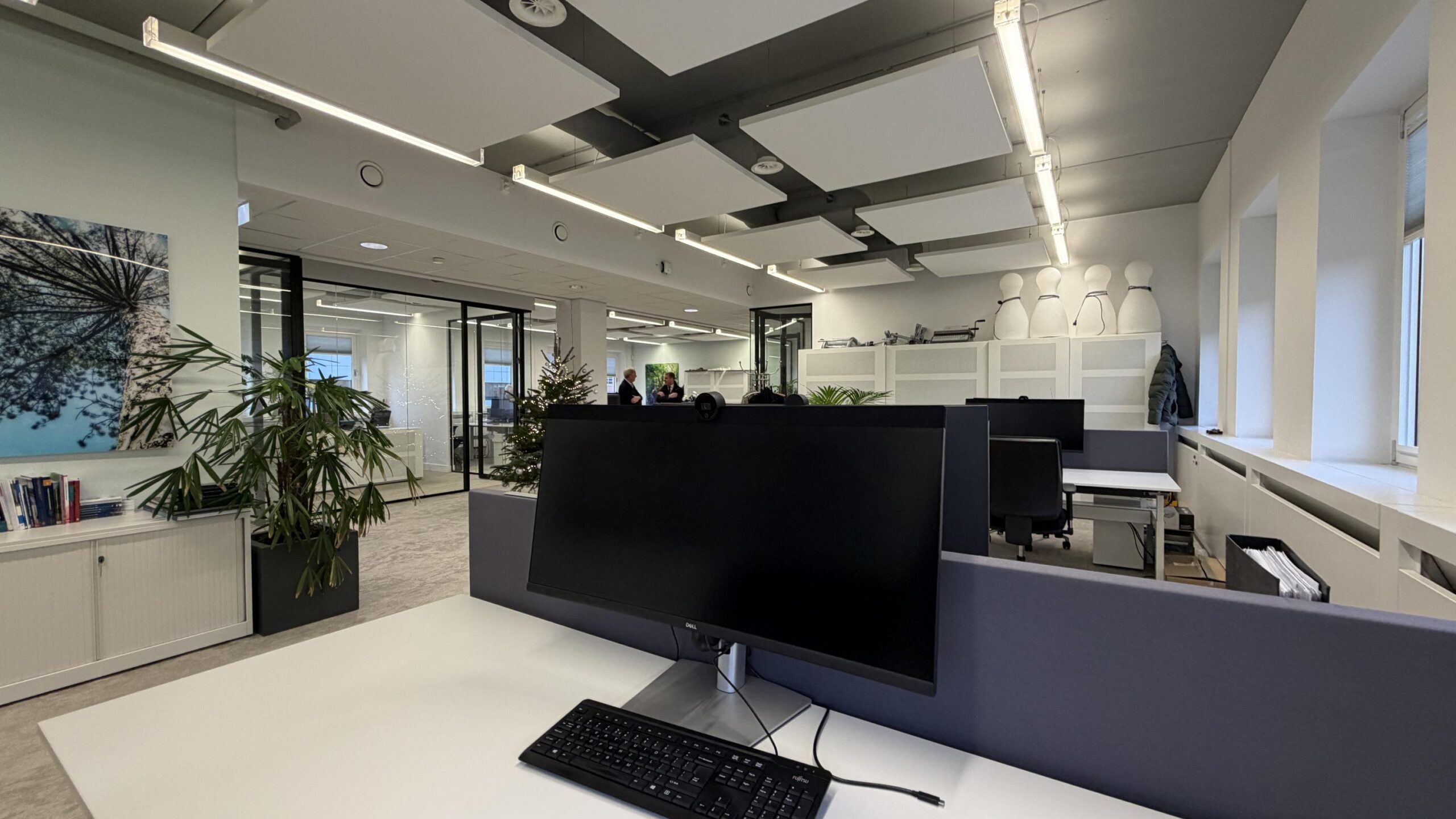 Modern kantoorinterieur aan de Euclideslaan met werkplekken, planten en glazen vergaderruimtes.