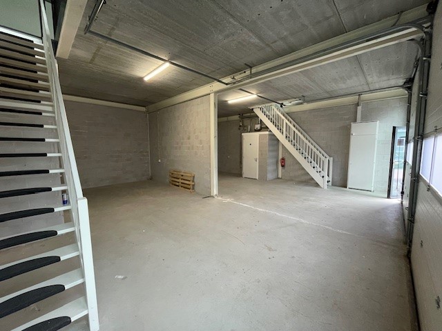 Leegstaand bedrijfs- of magazijnpand aan de Laan van s-Gravenmade met betonnen vloer, trap en hoge plafonds.