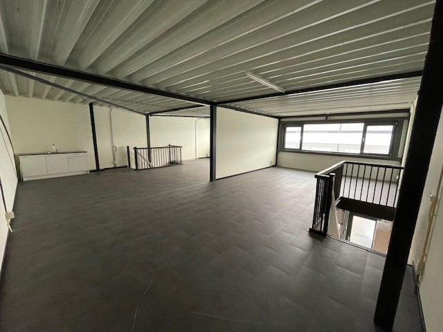 Kantoorruimte op de eerste verdieping aan de Laan van s-Gravenmade met grote ramen en een trap naar beneden.