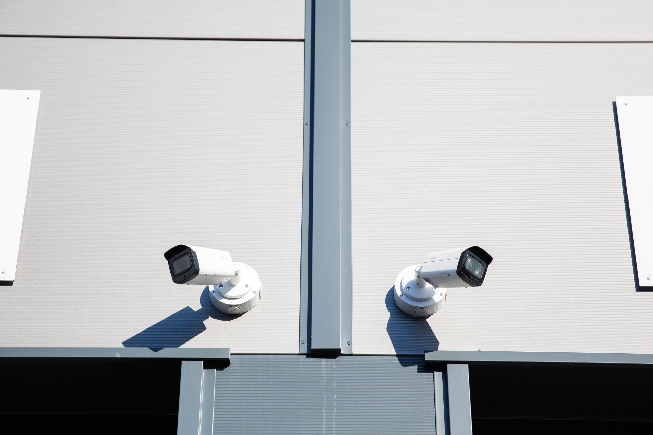 Twee beveiligingscamera's bevestigd aan de gevel van een modern bedrijfsgebouw aan de Laan van ’s-Gravenmade.