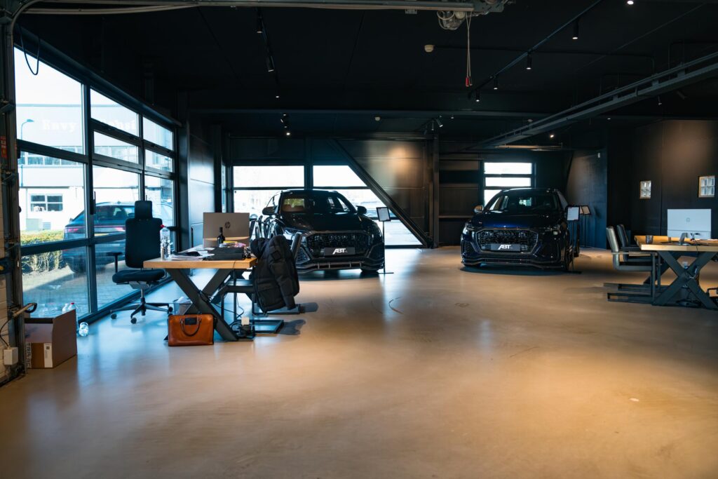 Moderne showroom met werkplekken en twee zwarte ABT getunede Audi's aan de Frankfurtstraat.