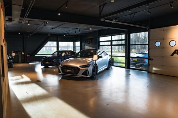Drie luxe ABT-getunede Audi’s staan opgesteld in een moderne showroom aan de Frankfurtstraat.
