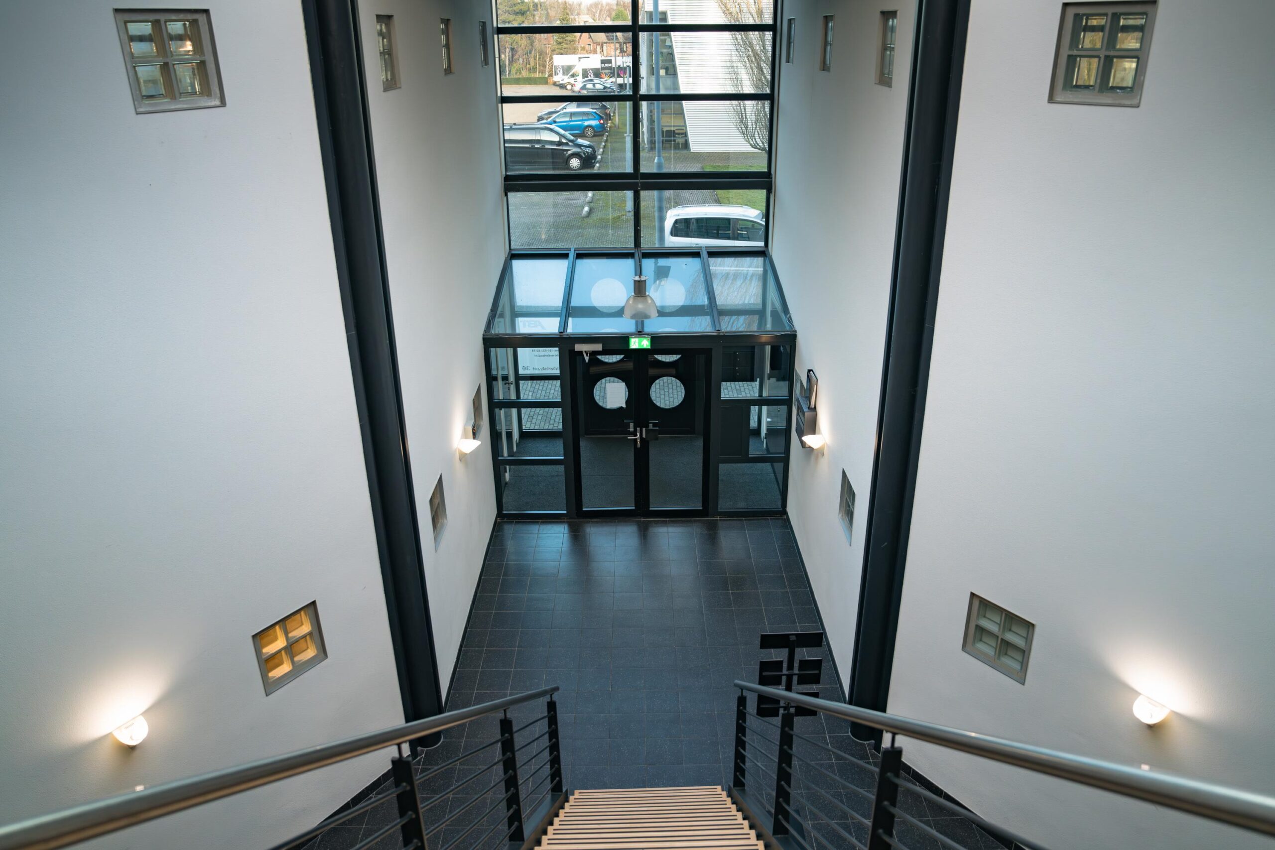 Inkomhal met trap en glazen entree in een modern kantoorgebouw aan de Frankfurtstraat.