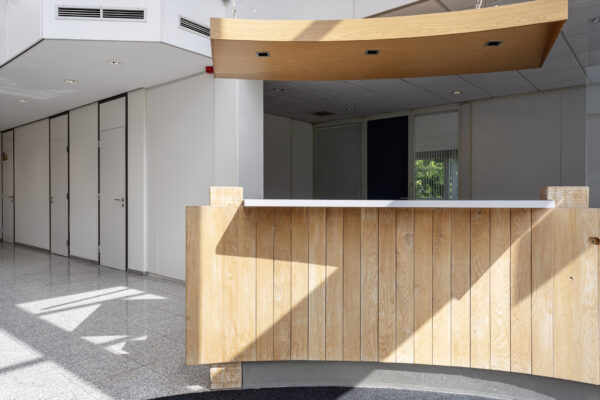 Receptiebalie van hout in een lichte, moderne kantoorruimte aan de Energieweg.
