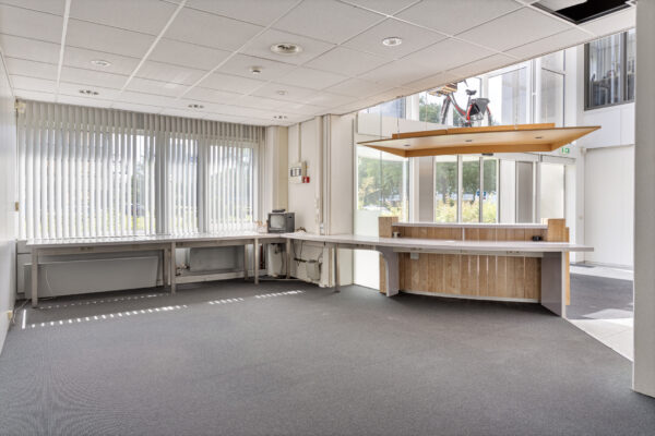 Lege kantoorruimte met grote ramen, een balie en werktafels aan de Energieweg.