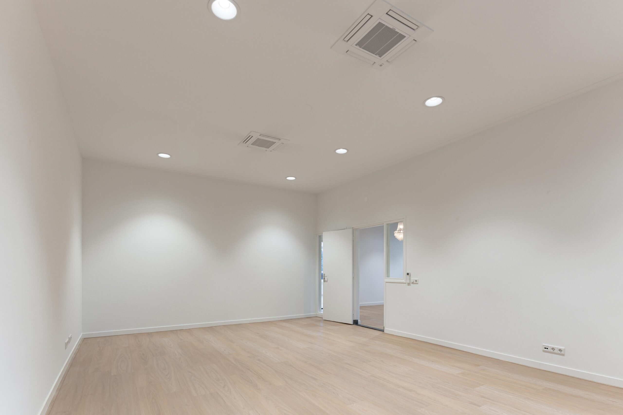 Lege, modern afgewerkte kamer met houten vloer en witte muren aan de Biltstraat.