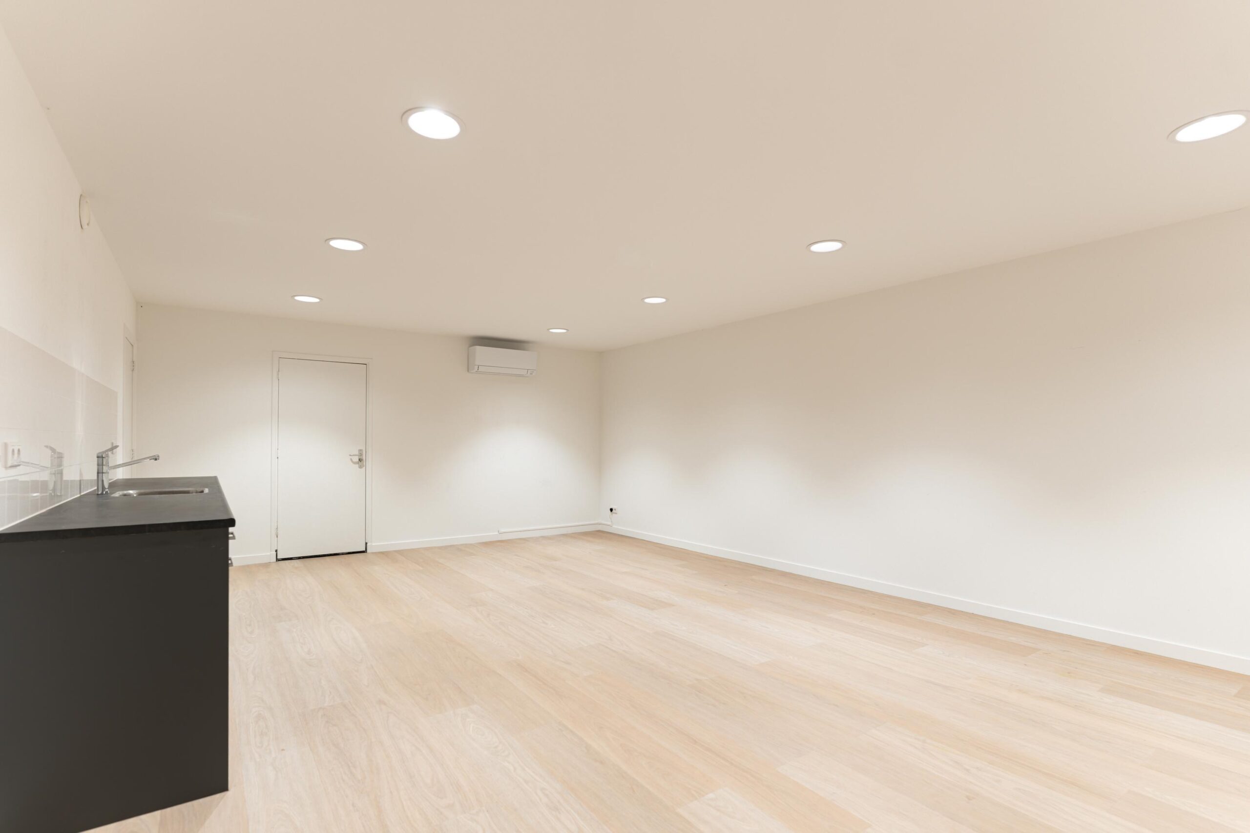 Lichte, lege kamer aan de Biltstraat met houten vloer, inbouwspots en een kitchenette.